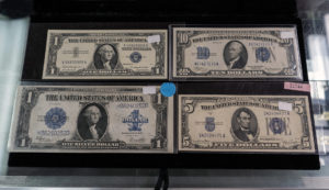exposed old banknotes of one, ten five and one silver dollar from Texican Rare Coin, Tyler, Texas